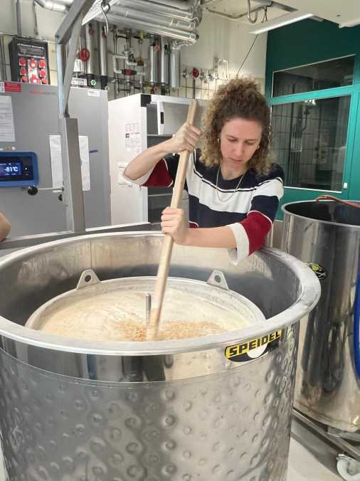 student stirring a pot of barley malt